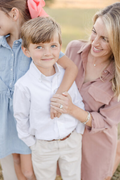 Young boy smiling while his mother looks on -Family Photographer Greenville SC