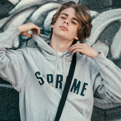 teen boy in supreme sweatshirt in los angeles with grafitti