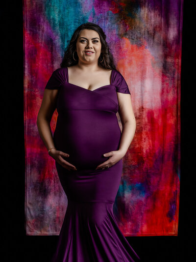 Royal purple dress against bold background in Prescott AZ maternity photos by Melissa Byrne