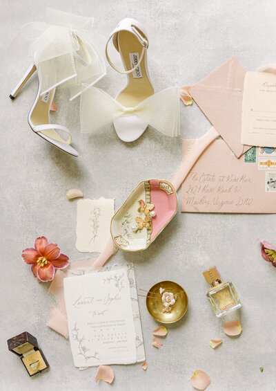 Pink and gold flatlay with shoes, invitations, and accessories