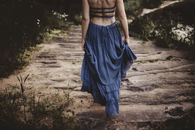 Soft portrait of Caroline walking along a cliff, embodying trust, inner strength, and connection to earth energy.