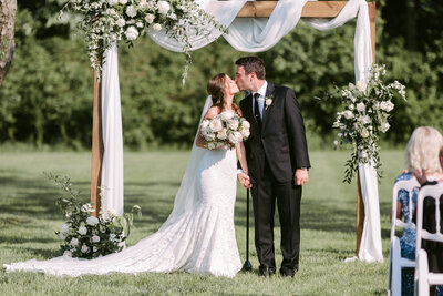 Chic wedding ceremony floral arch designed by Leigh Florist with cascading greenery and blush pink roses for a timeless look.