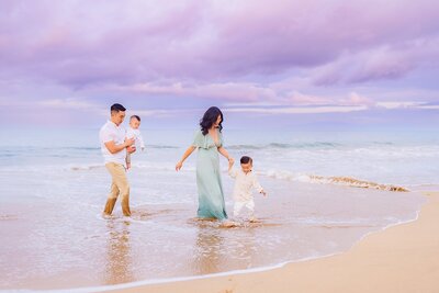 family of three smiles for camera during their hawaii lahaina photoshoot