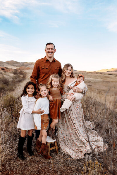 denver photographer poses beautiful fmily against the mountains at sunset
