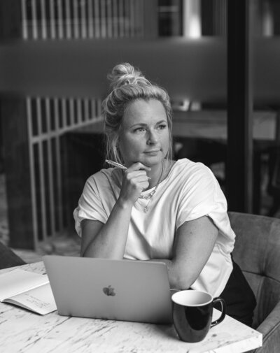 Brand & Website Designer and the founder of Sparkle Creative Studio designing on her laptop