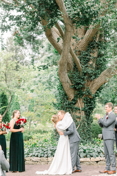 first kiss during garden wedding ceremony