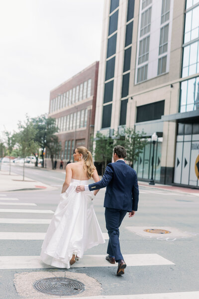 bride and groom walking in crosswalk in downtown fort worth by Kortney Boyett Photography, Fort Worth wedding photographer