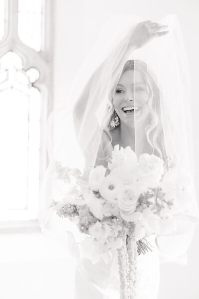 classic black and white, bright light and airy wedding photo of bride with bouquet