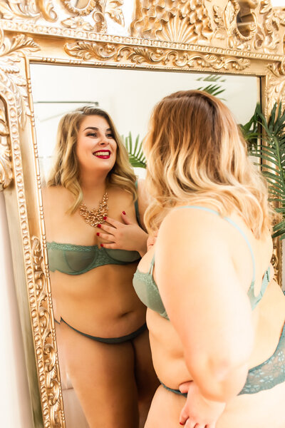 Beautiful woman smiles at herself in a mirror