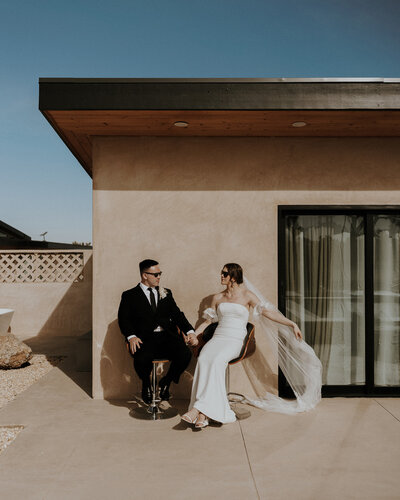 A stylish couple pose in front of their luxe airbnb.
