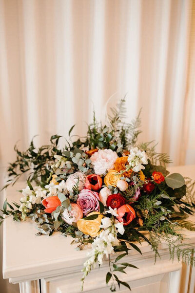 A large colorful floral arrangement laid on a white table