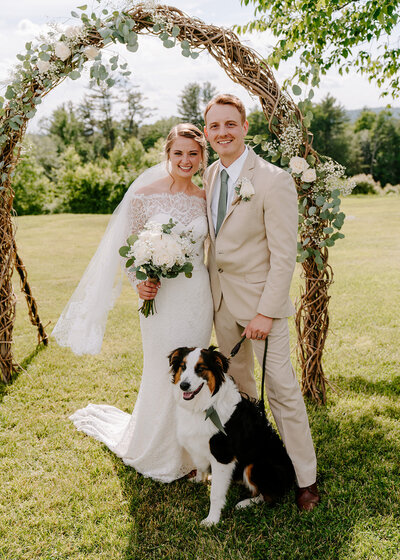 couple smiling and posing with their dog