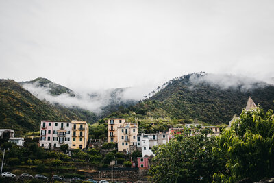 colourful italian homes tucked among the trees and clouds