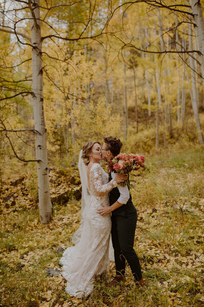Two brides kiss in an aspen grove in Telluride