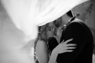 black and white image bride and groom kissing