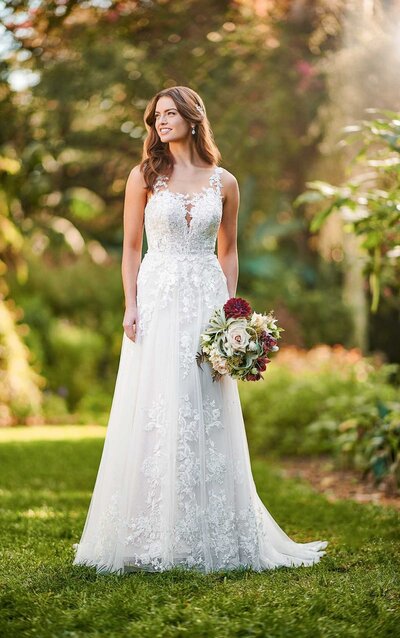 LAYERED LACE WEDDING DRESS Layers of breathtaking lace come together to give this lace wedding dress from Essense of Australia a unique and romantic update. A sweetheart neckline frames the face beautifully and sets the stage for romance, highlighting a sheer, lace-detailed bodice. Featuring embroidered lace on top of French lace, the layers on this gown create a unique texture and depth. The rich lace pattern of the bodice continues down through the skirt and is finished with a scalloped-lace hem. The sheer bodice continues around the back and is accented with a slight train. The back of this lace wedding dress zips up beneath fabric-covered buttons and is available beaded or unbeaded.