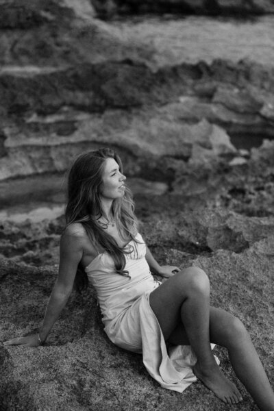 Photographer sitting on the rocks and posing for a personal branding photoshoot