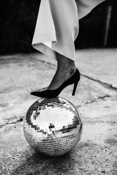 Woman's heels stepping on top of a disco ball