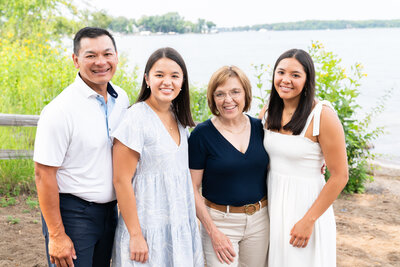 A family huddles together and smiles to the camera for their family pictures.