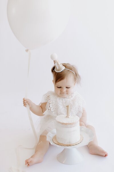 Sweet newborn baby girl wearing a beige bow is kissed by bother her parents