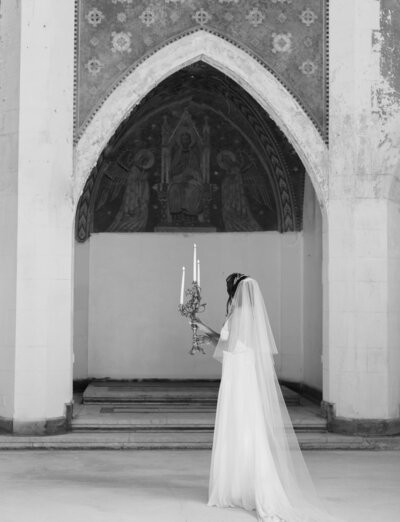 bride with long veil, candelabra, explores ruins wedding venue in Italy, destination film wedding photographer