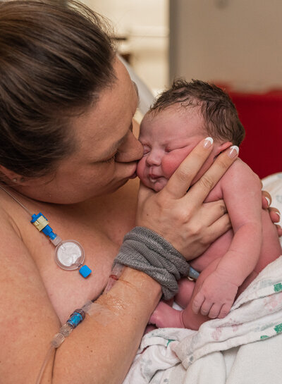 mom kissing just birthed baby at Longs Peak Hospital in Colorado