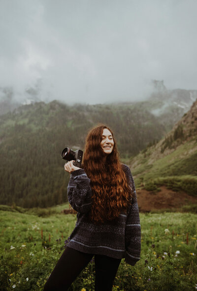 San Juan Mountains elopement photographer holds camera and smiles