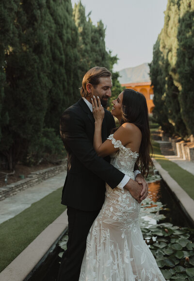 bride holding grooms face in her hand