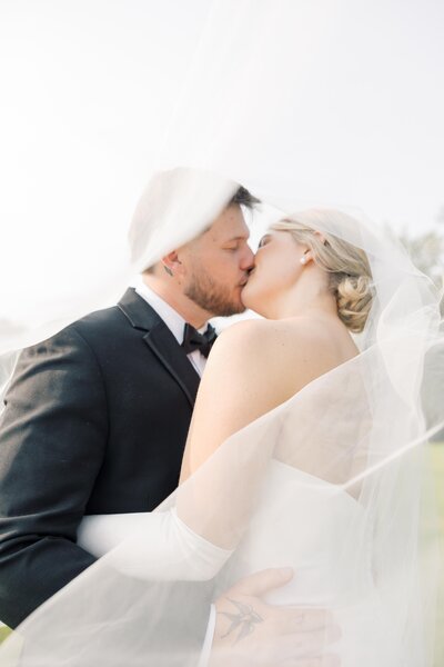 South Carolina Wedding Photography | Bride and groom kissing on wedding day under veil