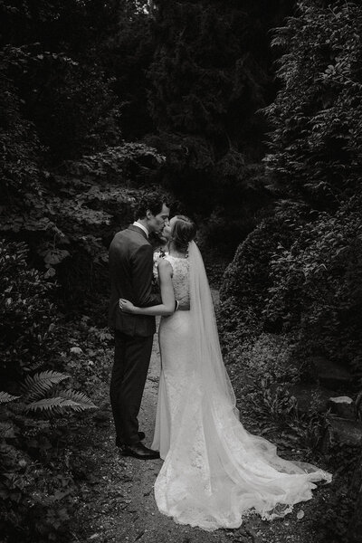 Een kussend bruidspaar tijdens de fotoshoot