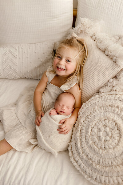 big sister holding her baby brother in denver photography studio