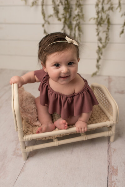 Baby girl wrapped in blush on white bed