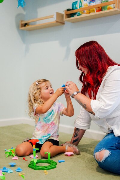 Ms. Jo playing with a student at The Nest, a natural learning center in Surf City, NC