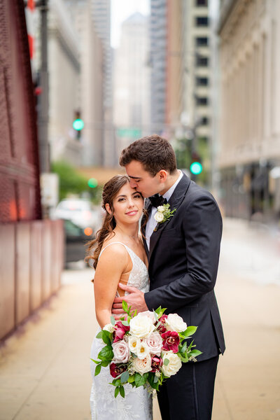 Groom kissing bride on the L aSalle Street Bridge in Chicago