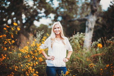 Woman standing among yellow wildflowers during a bright outdoor portrait session in Winter Garden, Florida.