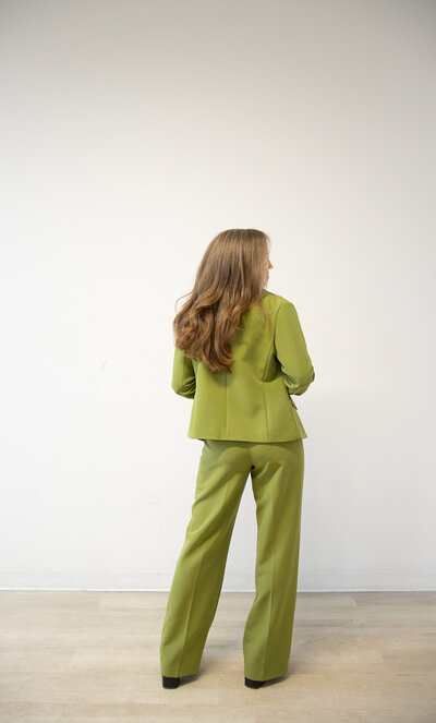 Content repurposing strategist in a green suit standing in a minimalist room, representing Perennial Content.