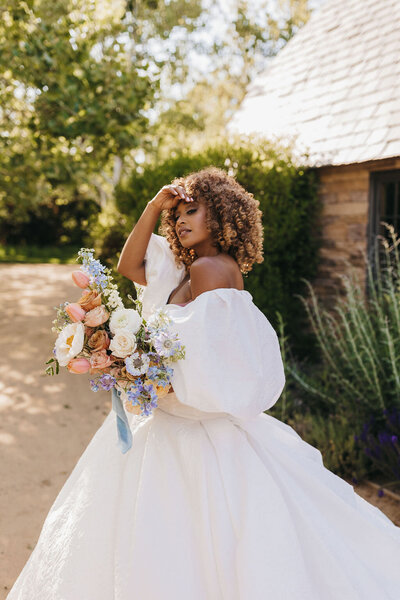 bride poses with bespoke wedding dress and florals 