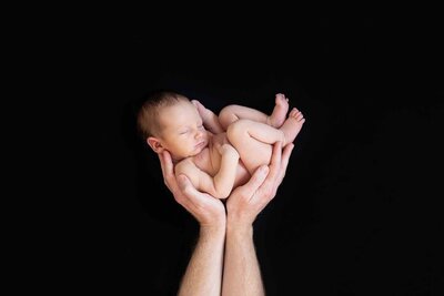 Eenvoudige en stijlvolle newborn shoot met een zwarte achtergrond.