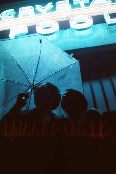 Washington DC wedding photographed on 35mm analog film in the pouring rain under neon lights