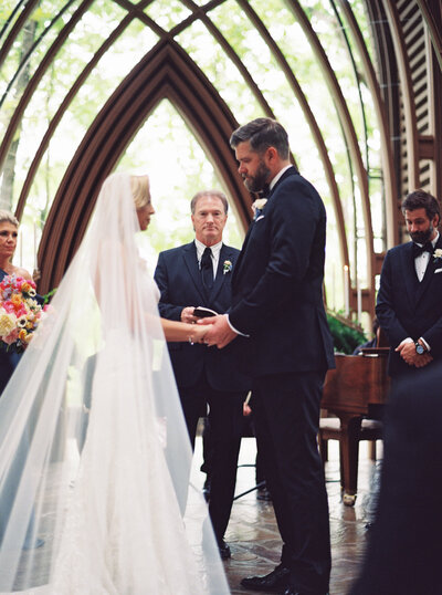 a wedding photo of a couple holding hands on the alter in Anthonys Chapel in Hot Springs Arkansas
