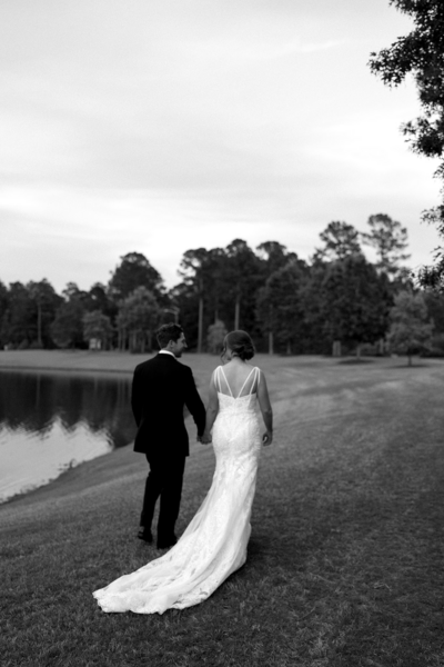 Romantic walk featuring the groom and bride alongside the water after their wedding ceremony in NC | Megan Smith Photography