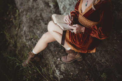 Caroline Weiss journaling in nature, reflecting her process of energy alignment and personal transformation.