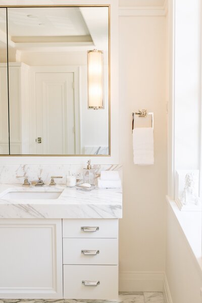 Bathroom design in a Beacon Hill brownstone featuring marble finishes, glass shower, and classic architectural details