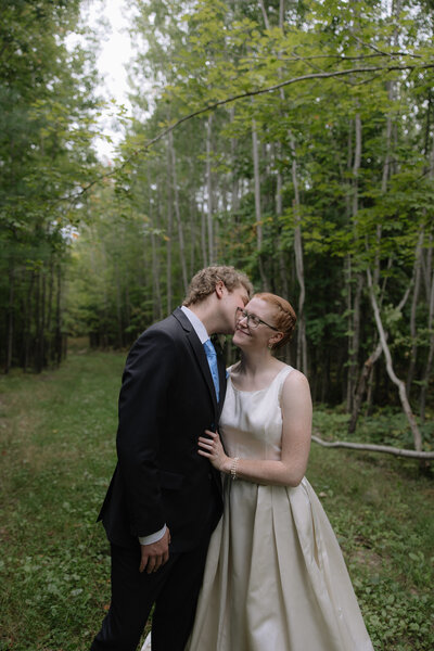 Couple embracing each other prior to celebrating their marriage in a beautiful forest in MN