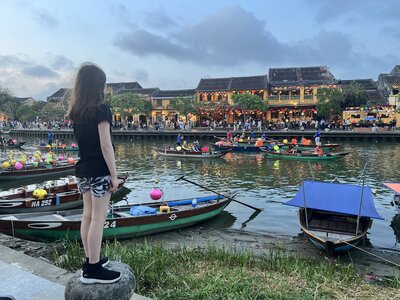Child standing by lantern-lit river in Hoi An, Vietnam — memories from childhood abroad featured on the expat parenting blog