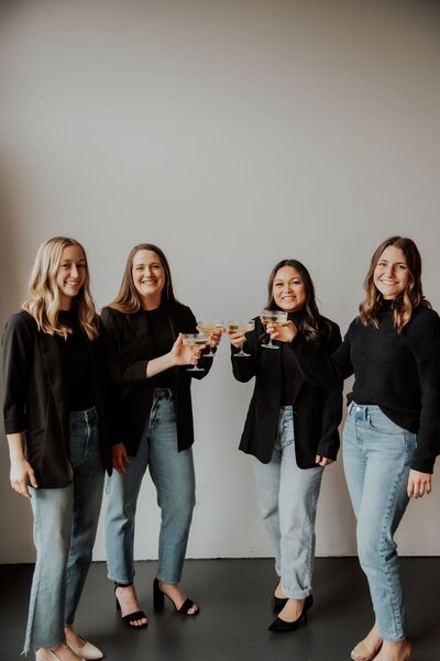 Four women saying cheers with champagne glasses