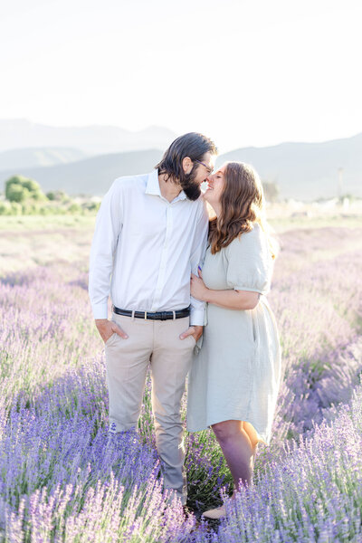 Candid engagement photo full of laughter and connection, captured in the Utah mountains and lavender. Natural light, genuine smiles, and playful posing make this session perfect for couples who want fun, relaxed photos.