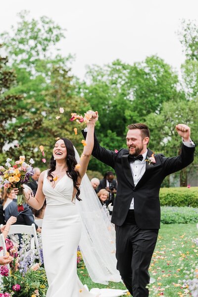Bride and groom exiting ceremony with flower petals planned by Bianca Nichole and Co