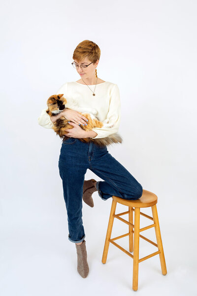 Studio portrait of Mia Lee and her cat on white backdrop