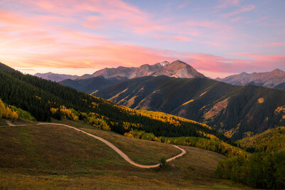 A pink sunrise over Annie's Basin and Cathedral Peak in fall on the back side of Aspen Mountain